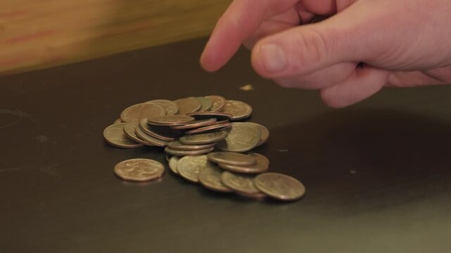 Counting a pile of quarters in close up.