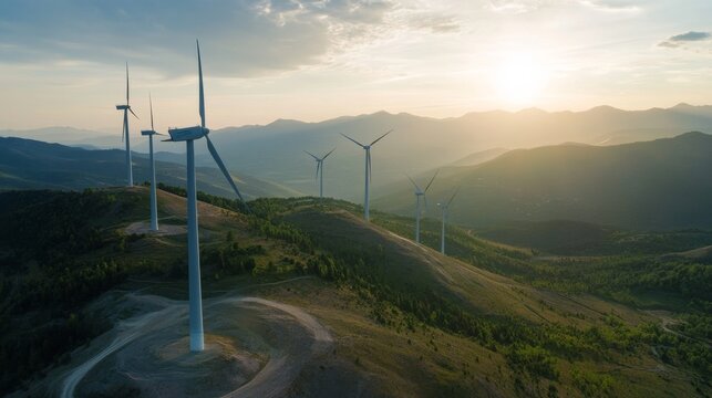 Wind turbines generate renewable energy during sunset in a hilly area near mountains in the countryside