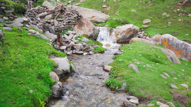 Wide angle shot of a scenic water stream flowing in the Himalayan mountain valley as seen from Sural Bhatori village in Pangi Valley of Chamba district, Himachal Pradesh, India. Natural background.