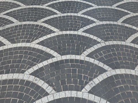 Close up of round fan shaped paving stone in arched or curved fan pattern. Suitable for pavement or sidewalk floor, for a vintage, classic, or European outdoor. Seamless background texture.
