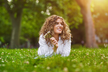 Obraz premium Pretty smiling authentic girl relaxing outdoor in summer by sunlight.