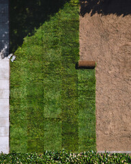 Naklejka premium Gardening. Making a lawn from a roll. Green grass texture - well-groomed turf in the garden. View of the garden from above.