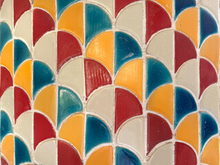 Texture of Japanese fish scales or Chinese fish skin wave and curve pattern. Asian curved fan and fish scales pattern, in vibrant blue, yellow, red, and beige color. Seamless background texture. © TMR Studio