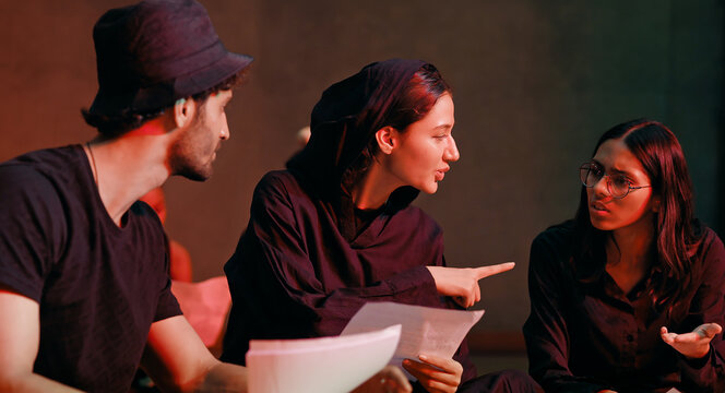 Indian young adult gen z male man female group hold script paper read new story line learn drama at studio teen girl boy team talk speak share new plan idea enjoy day spend break time hall stage place