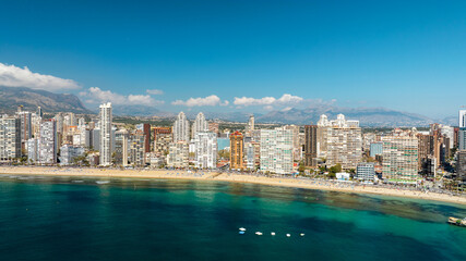 Fototapeta premium Benidorm Spain aerial drone view seaside resort modern architecture skyscrapers blue sky mountains background summer tourism holiday destination scenic.