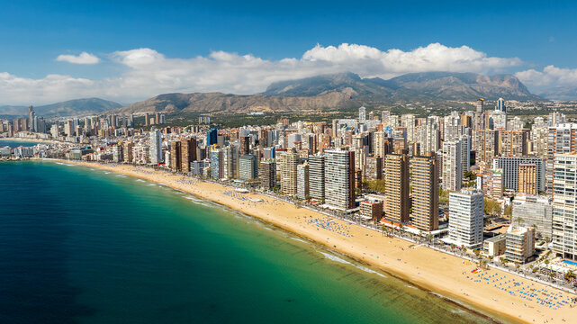 Aerial view Benidorm coastline skyscrapers Spain. Modern urban landscape beach and turquoise Mediterranean water. Spring sunny day mountain landscape background. Vacation and property concept.