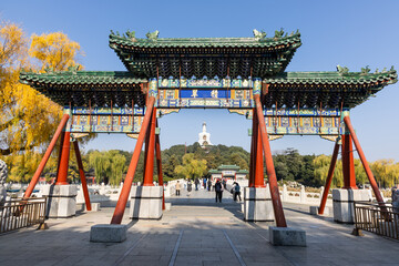 Obraz premium Entrance bridge that connects Jade Flower Island in Beihai Park with unrecognizable people. Chinese words translated as Emerald Product in English.