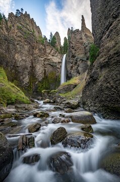 Waterfall flowing through eroded landscape with rock outcrops, Tower Fall with Tower Creek, Yellowstone National Park, Wyoming, USA