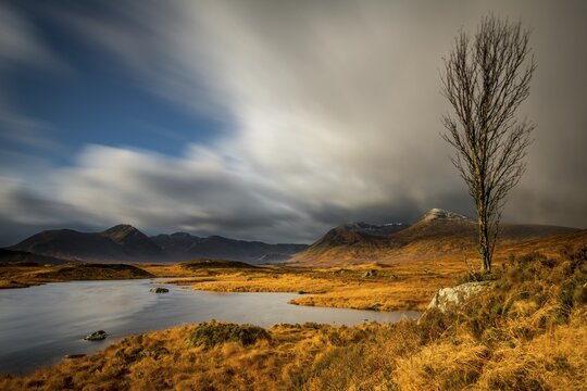 River Ba with mountain peaks of Meall a&acute;Bh&uuml;iridh and Clach Leathad in the background and dramatic clouds, Glen Coe, Rannoch Moor, west Highlands, Scotland, United Kingdom