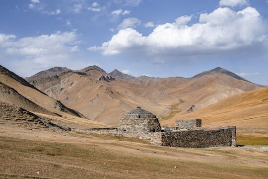 Historic caravanserai Tash Rabat from the 15th century, with yellow hills, Atbashy district in the Naryn region, Kyrgyzstan