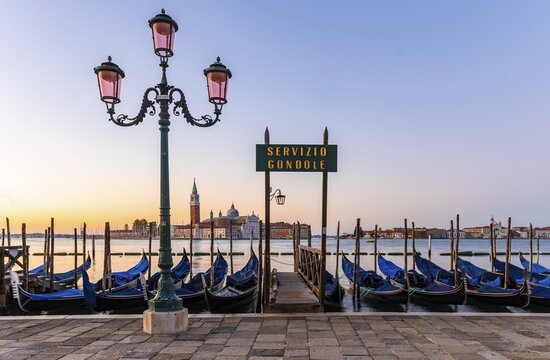 Venetian gondolas at St. Mark's Square in the evening light, blue hour, in the back monastery San Giorgio Maggiore, district San Marco, Venice, region Veneto, Italy