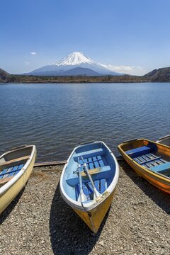 Rowing boats on the shore, view over the lake to the volcano Mt Fuji, Motosu Lake, Yamanashi Prefecture, Japan