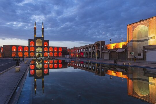 Amir Chaqmaq complex facade illuminated at sunrise and reflecting in a pond, Yzad, Yazd province, Iran