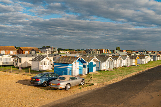 Rows of traditional colorful beach huts on the sandy dunes of Heacham North Beach, Norfolk, England.