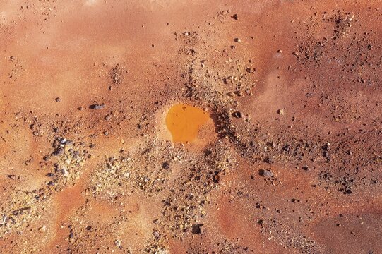 Little pool and extremely mineral-rich ground in the area of the Rio Tinto mines, the colour is caused by oxidised iron minerals, aerial view, drone shot, Huelva province, Andalusia, Spain