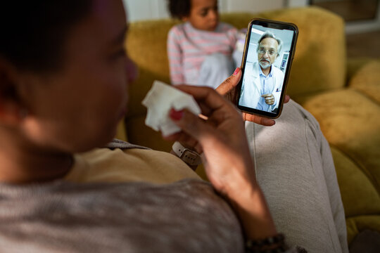 Mother consulting doctor by video at home