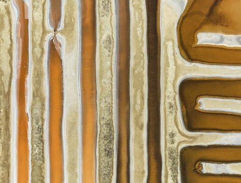 Saline ponds at the salt works near Chiclana de la Frontera. The orange-red colour depends on the level of salinity and is directly caused by the algae Dunaliella salina and brine shrimp. Aerial view. Drone shot. C&aacute;diz province, Andalusia, Spain