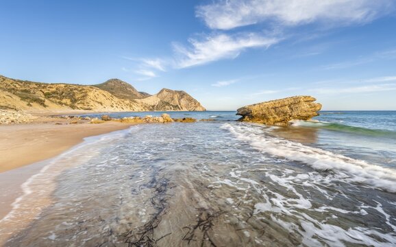Rocks in the water, waves crashing against rocks, sandy beach with rocky cliffs, Paralia Paradisos, Kos, Dodecanese, Greece