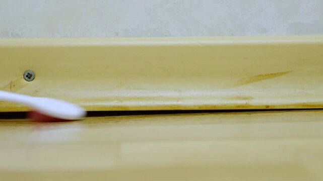 Thorough cleaning process. Systematic approach to cleaning narrow crevices thoroughly. Methodically scrubbing tight corners and edges for spotless baseboard and crevices