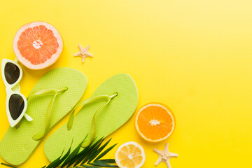 Naklejka premium Top view composition of flip flops placed with beach accessories top view on table background. Tropical summer vacation concept Flat lay