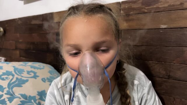 Young girl with braids wears nebulizer mask misting ventolin for asthma