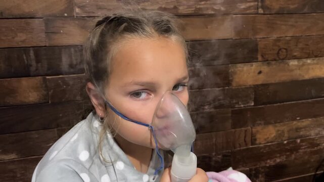 Closeup young girl with asthma breathes nebulized salbutamol medication