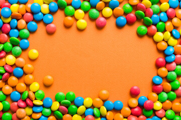 Obraz premium Mixed collection of colorful candy, on colored background. Flat lay, top view. frame of colorful chocolate coated candy