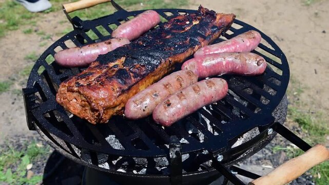 seasoned pork ribs and sausages grilling over an open charcoal fire
