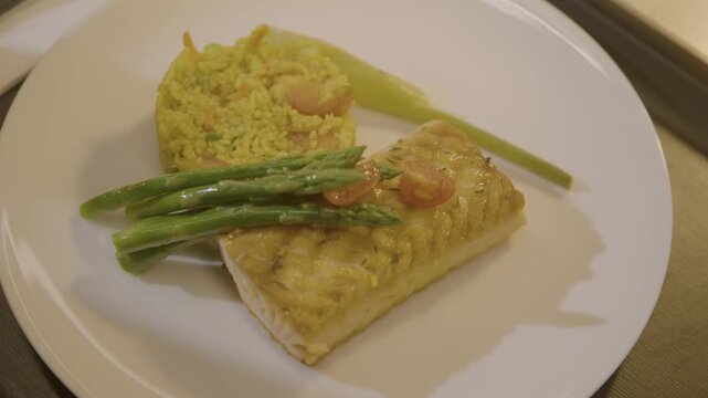 Cooked Fish Fillet with Asparagus and Rice Served on White Plate