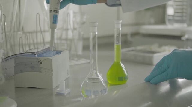 Lab Technician Handling Chemicals and Glassware During Scientific Experiment