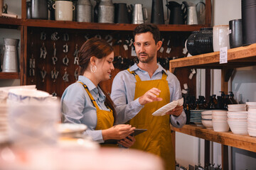 Cafe staff in apron discussing order in kitchen storage room