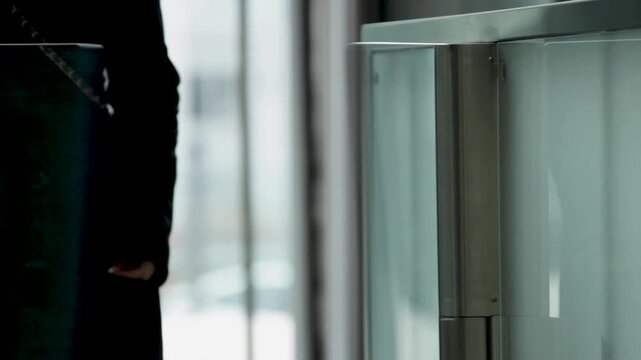 Person Approaching and Passing Through Glass Security Gate in Office Building Lobby