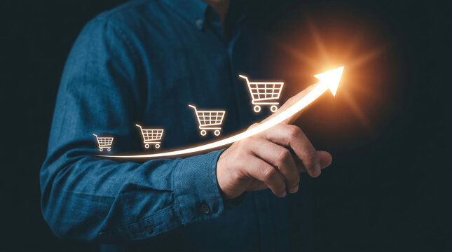 E-commerce sales growth concept, businessman pointing at rising arrow with shopping cart icons, retail marketing success and financial profit increase