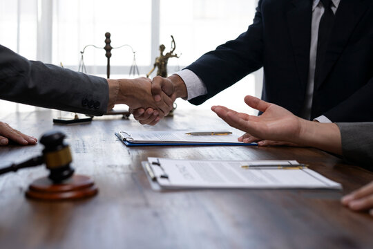 Lawyers shaking hands after signing a business contract in a law firm