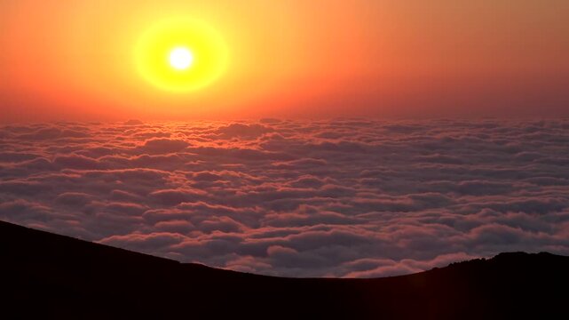 Time lapse sunset over sea of clouds above mountain landscape at dusk panorama in rural countryside. Flowing vapor and glowing afterglow create a dreamy scene with shifting layers and soft tones.