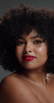 Face, woman and comb with haircare in studio with curly texture, natural growth and maintenance. Portrait, person and brush with coil hair for styling treatment, grooming benefits and gray background
