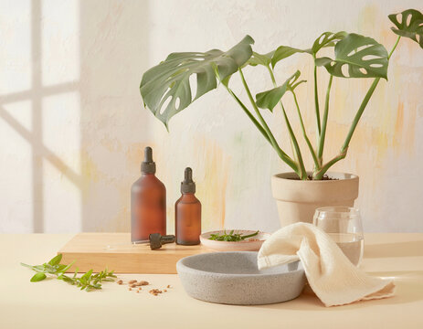 Medicinal plants sit on a table with cannabis leaves and bottles.