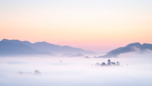Mountains silhouetted in misty sunrise