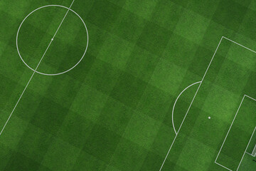 Aerial view of a green soccer field showing the center circle, penalty area, and goal. fresh grass texture and precise white markings create a professional atmosphere for sports and training concepts. © alones