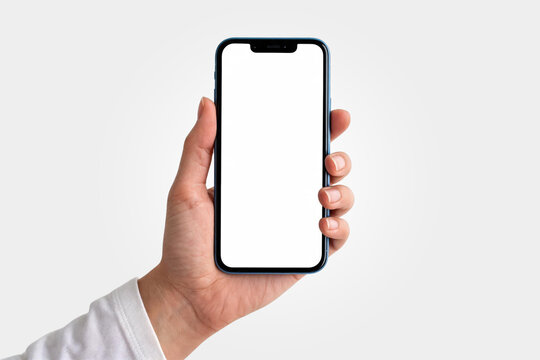 A Hand holding modern smartphone with blank white screen on white background.