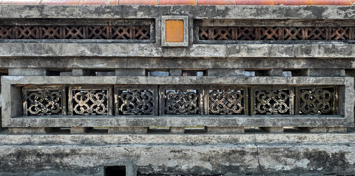 Close up pattern of molded clay blocks or ceramic Roster, in flower pattern, installed on a weathered aged wall. Found in old ruins or ancient palace or building. Heritage concept. Seamless texture