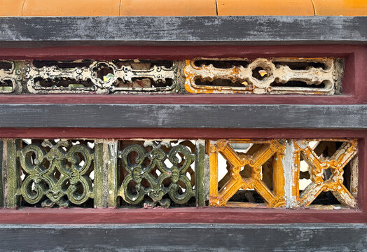 Colorful vibrant painted molded clay blocks or ceramic Roster, in flower pattern, installed on a weathered aged wall. Found in old ruins or ancient palace or building. Heritage concept. Seamless textu