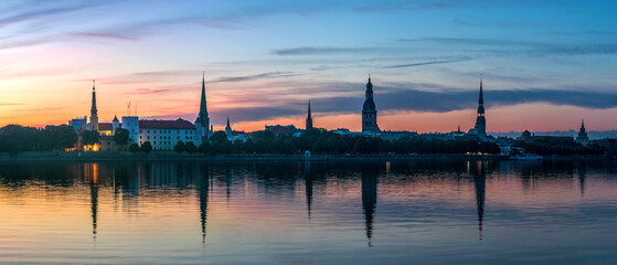 Naklejka premium Panoramic view of Riga city skyline at sunrise with Saint Peter church and Daugava river reflection