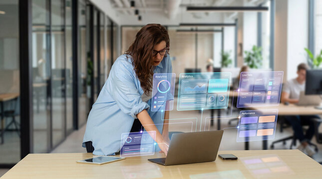 Digital professional woman managing performance dashboards on laptop in modern office