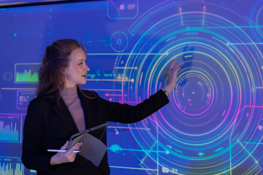 Speaker in a professional outfit presents the business technology concepts at a technology conference