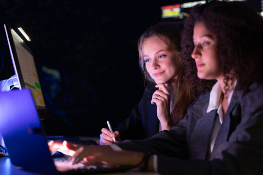 Colleagues discuss stock market trends in a modern office setting during evening hours