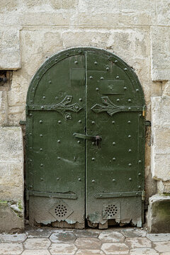 Ancient green metal arched entrance door