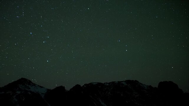 Stars glow above rugged mountain silhouettes under a clear night sky in serene wilderness. Dark peaks, nocturnal landscape, and astrophotography create tranquil cosmic atmosphere and science value.