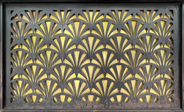 Close up of floral shape laser cut cutout carved on a black panel. Classic ornamental decoration with yellow background. Seamless background texture.