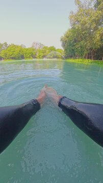 Vertical video. First Person View Releasing Large Alligator Gar Fish Into Clear Pond Water, Hands Letting Go As Fish Swims Away Creating Ripples, Wide Angle Perspective, Outdoor Fishing Scene